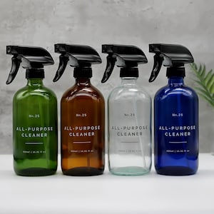 Può includere: Quattro flaconi spray in vetro verde, ambra, trasparente e blu, ciascuno con un ugello nero. Le bottiglie sono etichettate "No. 25 ALL-PURPOSE CLEANER" con una capacità di 500 ml. Design minimalista per la pulizia della casa.