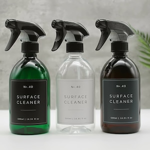 May include: Three glass spray bottles with black trigger sprayers and labels that read "No. 40 SURFACE CLEANER 500ml | 16.91 fl oz". The bottles are green, clear, and brown.