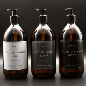 May include: Three amber glass bottles with black pump tops and white labels. Each bottle contains liquid hand soap and has the text "No. 42 LIQUID HAND SOAP 500ml | 16.91 fl oz" printed on the label.