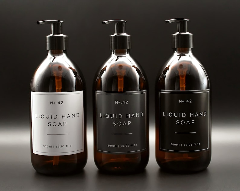 May include: Three amber glass bottles with black pump tops and white labels. Each bottle contains liquid hand soap and has the text "No. 42 LIQUID HAND SOAP 500ml | 16.91 fl oz" printed on the label.