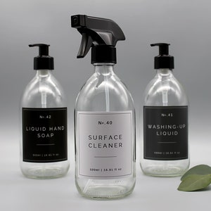 Puede incluir: Tres botellas de vidrio con tapas de bomba negras y etiquetas. Las botellas est&aacute;n llenas de l&iacute;quido transparente. Las etiquetas dicen "No. 42 LIQUID HAND SOAP", "No. 40 SURFACE CLEANER 500ml | 16.91 fl oz", y "No. 41 WASHING-UP LIQUID".