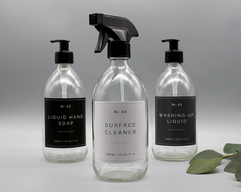 Puede incluir: Tres botellas de vidrio con tapas de bomba negras y etiquetas. Las botellas est&aacute;n llenas de l&iacute;quido transparente. Las etiquetas dicen "No. 42 LIQUID HAND SOAP", "No. 40 SURFACE CLEANER 500ml | 16.91 fl oz", y "No. 41 WASHING-UP LIQUID".