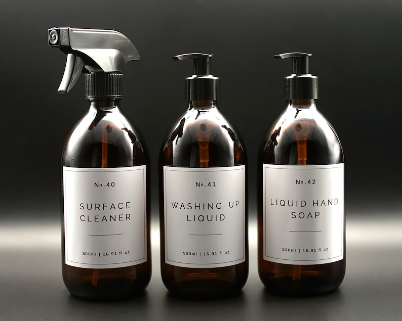 May include: Three amber glass bottles with black pump tops and white labels. The labels have black text that reads "No. 40 SURFACE CLEANER 500ml | 16.91 fl oz", "No. 41 WASHING-UP LIQUID 500ml | 16.91 fl oz", and "No. 42 LIQUID HAND SOAP 500ml | 16.91 fl oz".