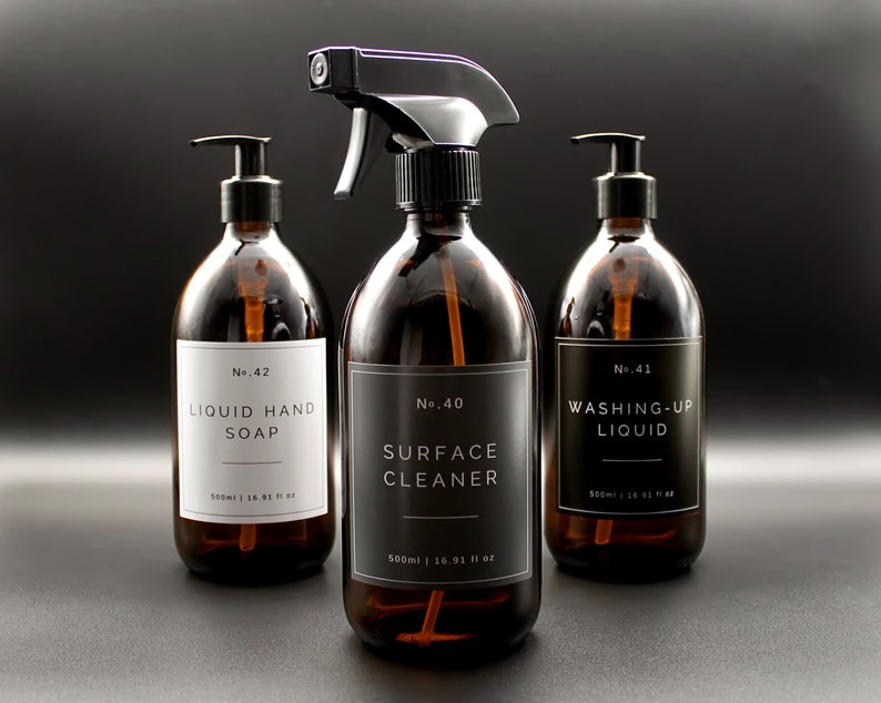 May include: Three amber glass bottles with black pump tops and labels. The labels are white with black text. The bottles are labeled "No. 42 Liquid Hand Soap", "No. 40 Surface Cleaner", and "No. 41 Washing-Up Liquid".