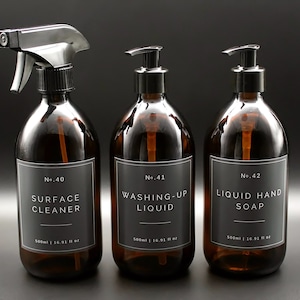 May include: Three amber glass bottles with black pump tops and labels. The labels are black with white text. The bottles are labeled "No. 40 Surface Cleaner", "No. 41 Washing-Up Liquid", and "No. 42 Liquid Hand Soap". Each bottle contains 500 ml or 16.91 fl oz.