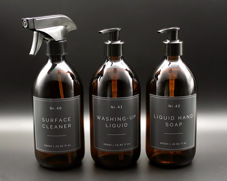 May include: Three amber glass bottles with black pump tops and labels. The labels are black with white text. The bottles are labeled "No. 40 Surface Cleaner", "No. 41 Washing-Up Liquid", and "No. 42 Liquid Hand Soap". Each bottle contains 500 ml or 16.91 fl oz.