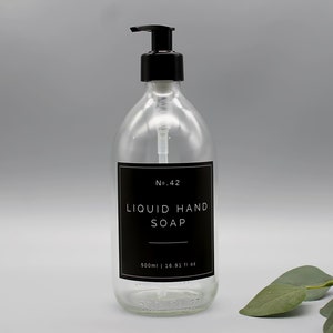 Puede incluir: Una botella de vidrio transparente con un dispensador de bomba negro lleno de jab&oacute;n l&iacute;quido para manos. La botella tiene una etiqueta negra con texto blanco que dice "No. 42 LIQUID HAND SOAP 500ml | 16.91 fl oz".