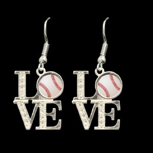 May include: Silver earrings with the word "LOVE" spelled out. Each letter has a baseball charm with red stitching.