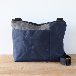 Grand sac à bandoulière en toile cirée pour homme et femme. Sac messager solide et résistant à l'eau avec fermeture éclair, poches et large bandoulière.