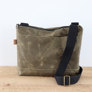 Grand sac à bandoulière en toile cirée pour homme et femme. Sac messager solide et résistant à l'eau avec fermeture éclair, poches et large bandoulière.