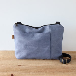 Sac à bandoulière en toile délavée pour homme et femme. Sac à main en toile décontracté pour un usage quotidien, avec fermeture éclair sur le dessus et poche extérieure sur le devant.
