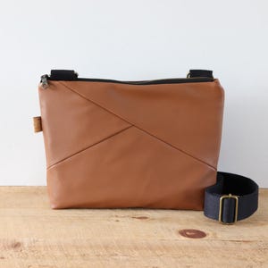 Porte-monnaie en cuir végétalien marron muscade pour femme. Sac à bandoulière chic en similicuir souple avec poches, fermeture éclair et large bandoulière.
