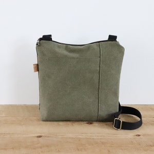 Sac à bandoulière en toile délavée pour homme et femme. Sac à main végétalien décontracté en toile avec poche avant et fermeture éclair sur le dessus pour un usage quotidien.
