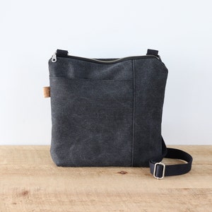 Sac à bandoulière en toile délavée pour homme et femme. Sac à main végétalien décontracté en toile avec poche avant et fermeture éclair sur le dessus pour un usage quotidien.