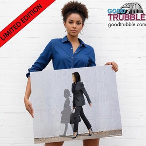May include: A black and white illustration of a woman walking with her shadow behind her. The woman is wearing a dark suit and carrying a briefcase. The text "GOOD TRUBBLE" and "goodtrubble.com" is visible in the upper right corner of the image.