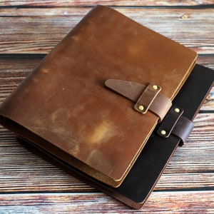 May include: A set of three ceramic mugs with a speckled, cream-colored glaze. Each mug features a different hand-painted floral design in shades of blue, green, and yellow. The mugs have a simple, rounded shape and a comfortable handle.