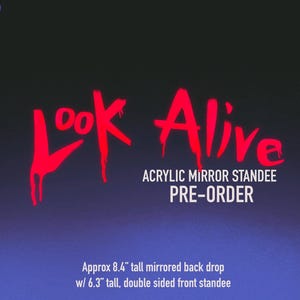 May include: An acrylic mirror standee featuring the red text LOOK ALIVE and the white text ACRYLIC MIRROR STANDEE PRE-ORDER. Two white line-art snakes frame the sides. Text indicates a 21.3 cm tall mirrored backdrop and a 16 cm tall front standee.