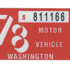 May include: A rectangular red sticker with white text and numbers. The number "73" is prominently displayed, along with the text "MOTOR VEHICLE WASHINGTON" and the number "811166".