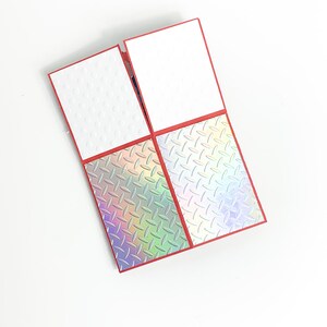 Puede incluir: Una tarjeta roja con cuatro patrones diferentes. Los dos patrones superiores son blancos con peque&ntilde;os c&iacute;rculos blancos. Los dos patrones inferiores son iridiscentes con un patr&oacute;n de diamante.