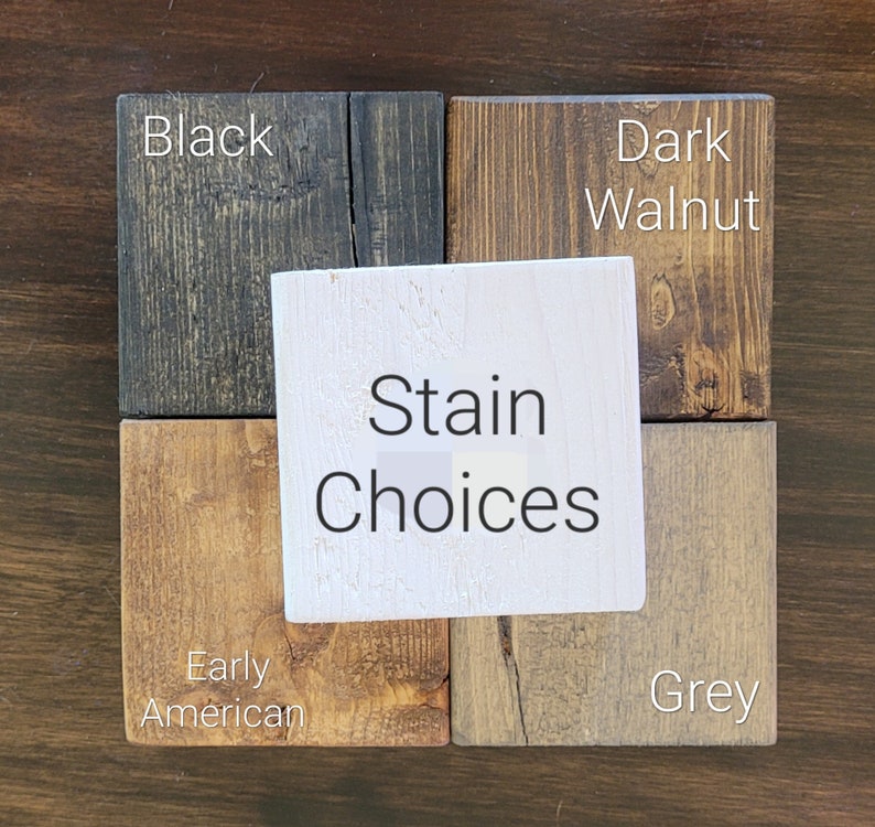 May include: A display of wood stain color options. The samples include Black, Dark Walnut, Early American, and Grey. A white square in the center reads "Stain Choices". The wood samples are arranged on a dark brown surface.