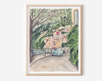 May include: A watercolor painting of a blue car driving on a winding road in a colorful Italian village. The road is lined with lush green trees and a stone wall. The village is built on a hillside and has many colorful buildings.