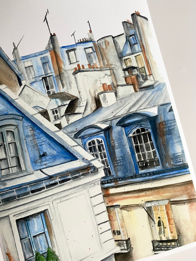 Puede incluir: Pintura acuarela de un paisaje urbano parisino con techos azules y grises, ventanas y chimeneas. Los edificios est&aacute;n pintados en un estilo realista con un enfoque en los detalles de la arquitectura.