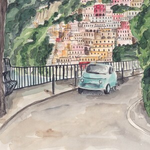 May include: A light blue vintage car parked on a street with a view of a colourful hillside town in the background.