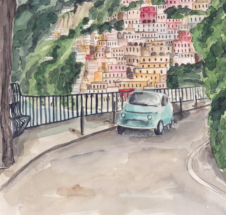 May include: A light blue vintage car parked on a street with a view of a colourful hillside town in the background.