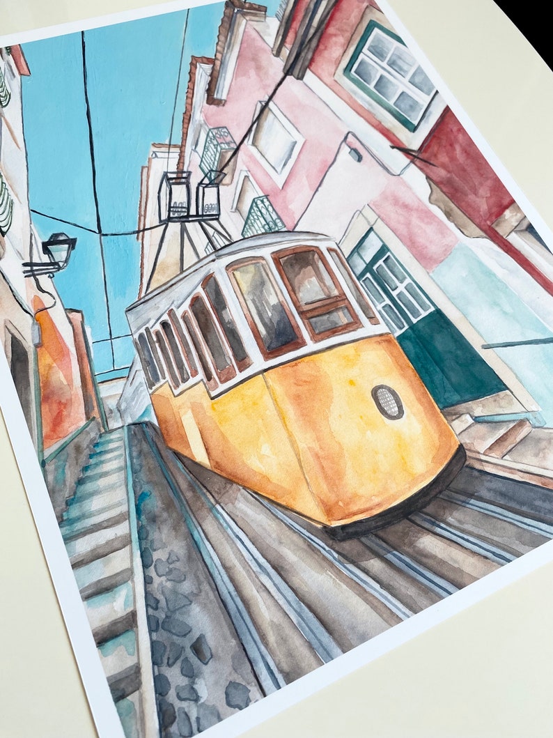 May include: Watercolor painting of a yellow tram traveling up a steep, cobblestone street in a city. The tram is traveling up a set of stairs with buildings on either side of the street.