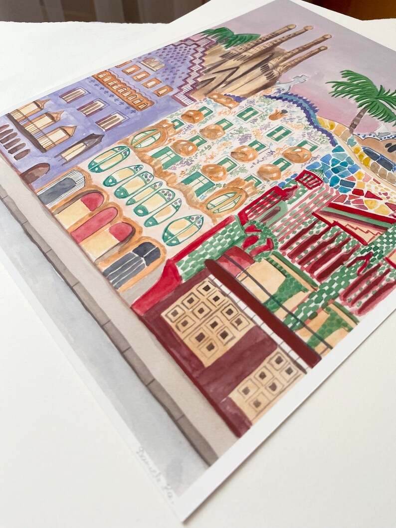 May include: Watercolor painting of a colorful building with a mosaic facade. The building has a green, red, and yellow color scheme. The building is surrounded by a light gray sidewalk. The painting is signed "Barcelona, Spain".