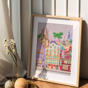 May include: A framed watercolor painting of colorful buildings with a palm tree in the foreground. The buildings are in a style reminiscent of Barcelona, Spain.
