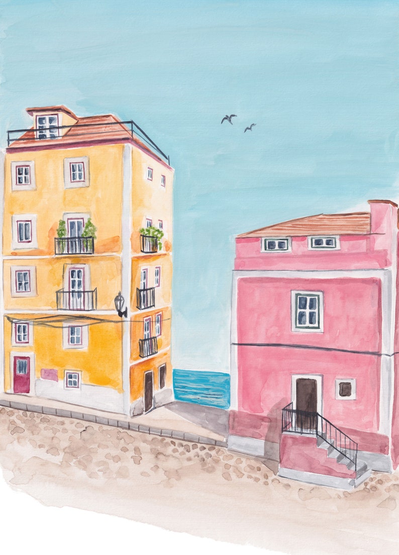 May include: Watercolor painting of two buildings on a cobblestone street. The building on the left is yellow with a red door and multiple windows. The building on the right is pink with a brown door and a staircase. The buildings are near a blue body of water.