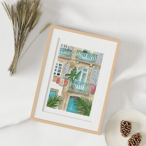May include: A watercolour painting of a building with a blue door and a balcony with a green plant. The building has a tiled facade with a blue and white pattern.