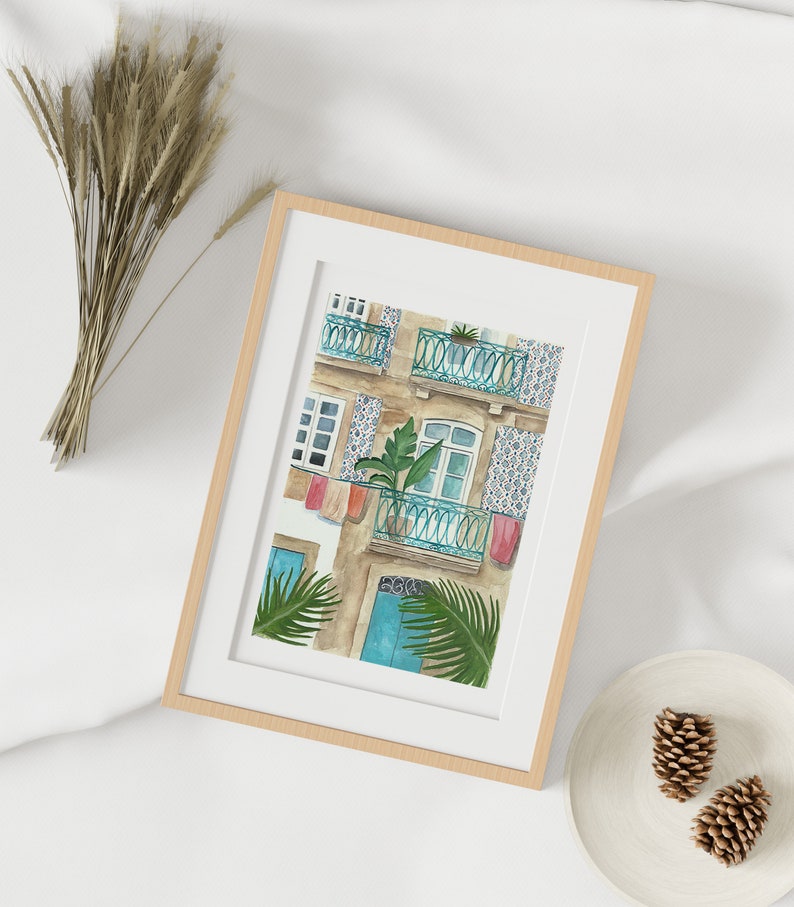 May include: A watercolour painting of a building with a blue door and a balcony with a green plant. The building has a tiled facade with a blue and white pattern.