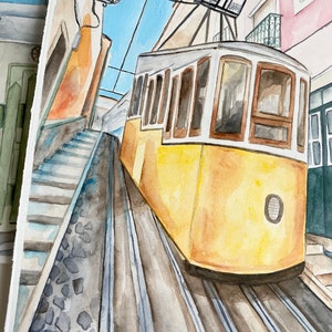 May include: Watercolor painting of a yellow tram traveling up a steep, cobblestone street in a city. The tram has large windows and a white roof. The street is lined with buildings on either side.