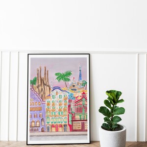 May include: A framed watercolor painting of colorful buildings with a pink sky in the background. The buildings are in a style reminiscent of Antoni Gaud&iacute;'s architecture.