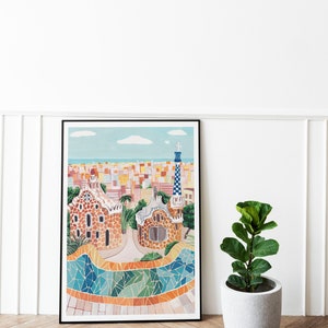 May include: A framed illustration of a colorful cityscape with a mosaic tiled walkway and two buildings with a unique architectural style. The buildings are brown with a textured surface and have a whimsical design. The cityscape is in the background and is a mix of yellow, orange, and white buildings.