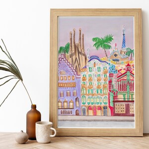 May include: A framed illustration of colorful buildings in Barcelona, Spain. The buildings are painted in a whimsical style with bright colors and geometric patterns. The illustration includes a palm tree and a blue sky.