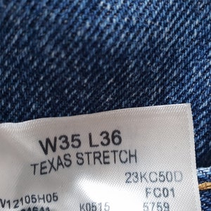 May include: A white tag with black text that reads "W35 L36 TEXAS STRETCH 23KC500 FCD1 W12105H05".