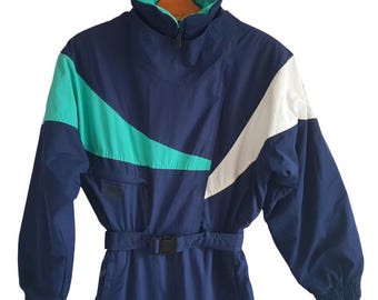 May include: A blue ski suit with white and teal accents. The suit has a zipper closure and a belt.