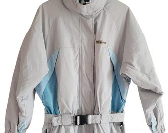 May include: A gray and blue ski suit with a belt and the word "Trespass" on the front.
