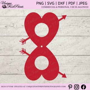 May include: Red heart-shaped cutout with two circles and arrows, for Valentine's Day crafts.