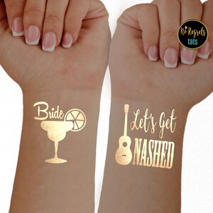 Puede incluir: Dos tatuajes temporales dorados, uno con una margarita y la palabra "Bride" y el otro con una guitarra y el texto "Let's Get Nashed".