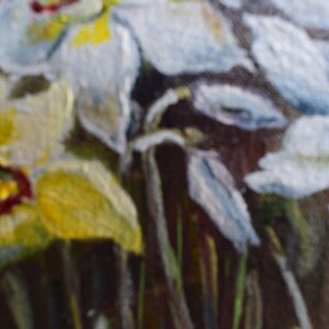 May include: A close-up of a painting of white and yellow flowers with green stems. The flowers are in focus, while the background is blurred.