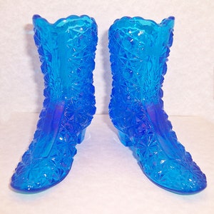 May include: A pair of blue glass boot-shaped vases with a diamond pattern.