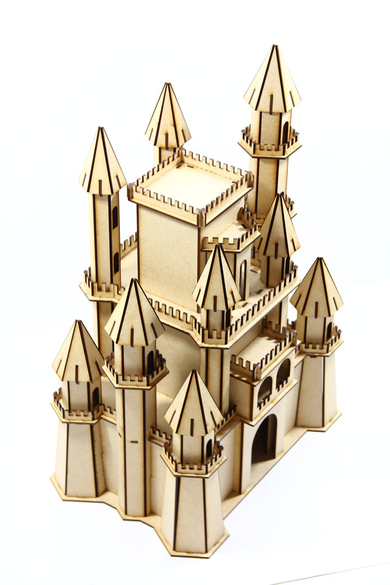 May include: A wooden model of a castle with multiple towers and a detailed facade. The castle is made of light brown wood and has a whimsical design.