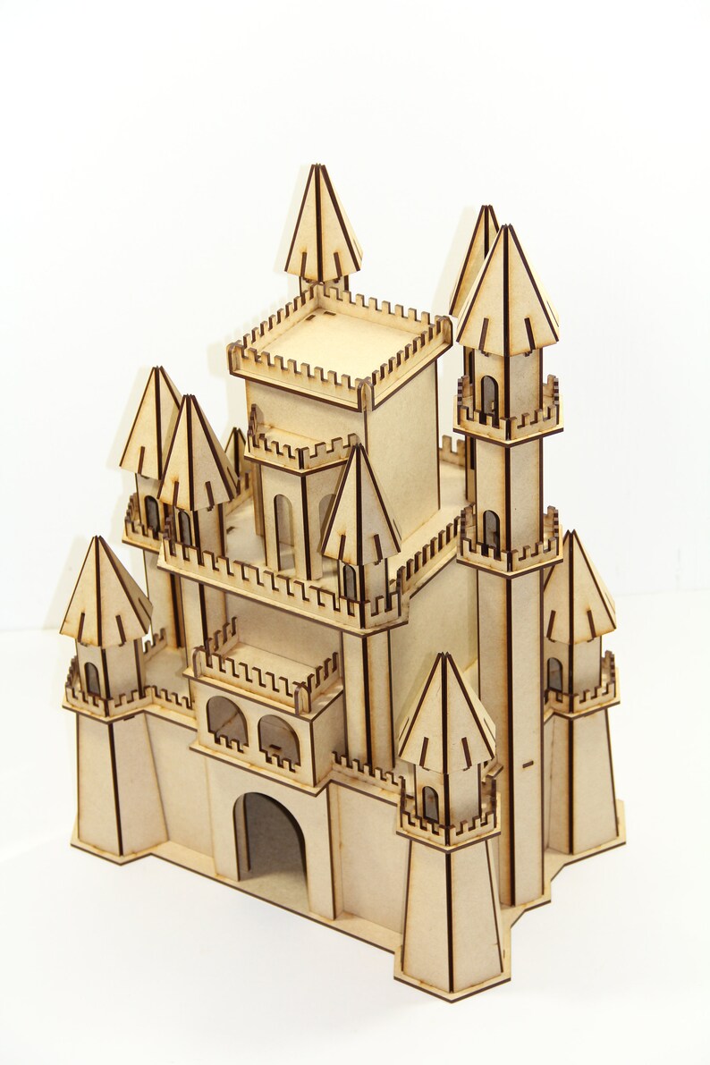 May include: A wooden model of a castle with multiple towers and a large central tower. The castle is made of light brown wood and has intricate details, including windows, doors, and a drawbridge.