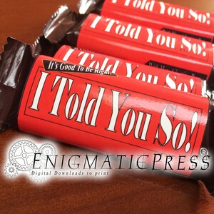 May include: Several red candy bar wrappers with the text "I Told You So!" in white. The wrappers also have the text "It's Good To Be Right." The candy bars are in a dark brown wrapper.