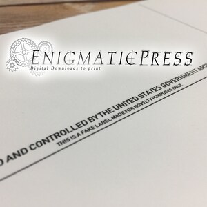 May include: A white paper with black text that reads "THIS IS A FAKE LABEL MADE FOR NOVELTY PURPOSES ONLY. AND CONTROLLED BY THE UNITED STATES GOVERNMENT ART" and the text "Digital Downloads to print ENIGMATIEPRESS".