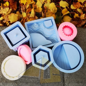 May include: Assortment of six different silicone moulds for crafting. The moulds are in various shapes, including a square, a circle, a rectangle, and a star. The moulds are all light blue and have a smooth, glossy finish.